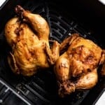 Roasted Cornish hens in an air fryer from the top view.