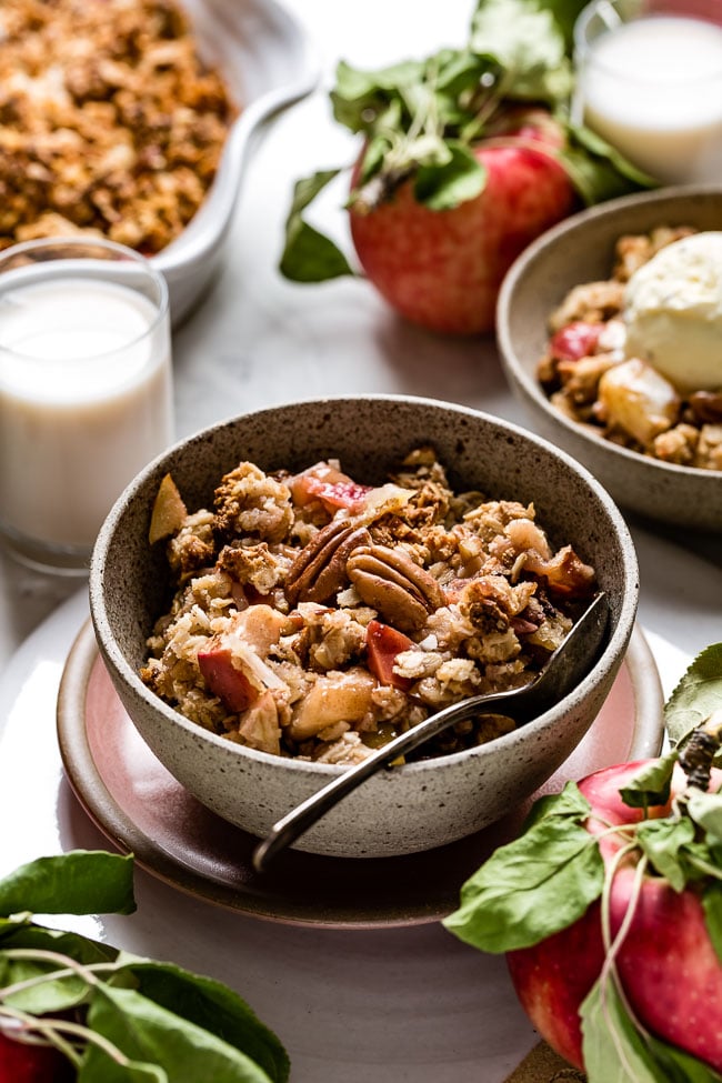 Vegan Apple Crisp placed in a bowl with milk on the side.