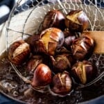 Boiled chestnuts being removed from the pot