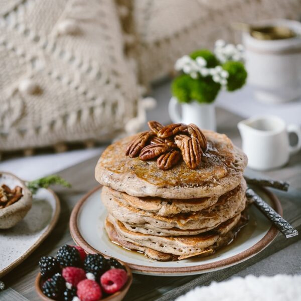 Buckwheat Pancakes Recipe on a bed setting with flours and tea in the background
