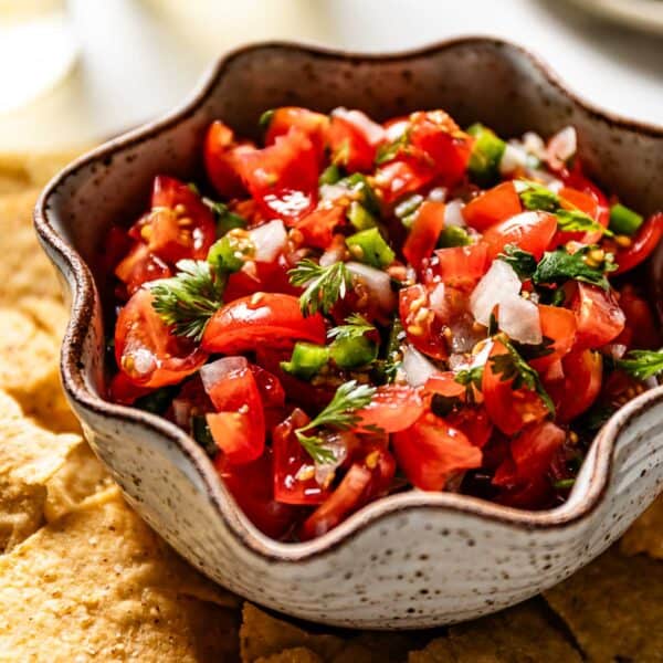 A bowl of Cherry tomato salsa with chips on the side.