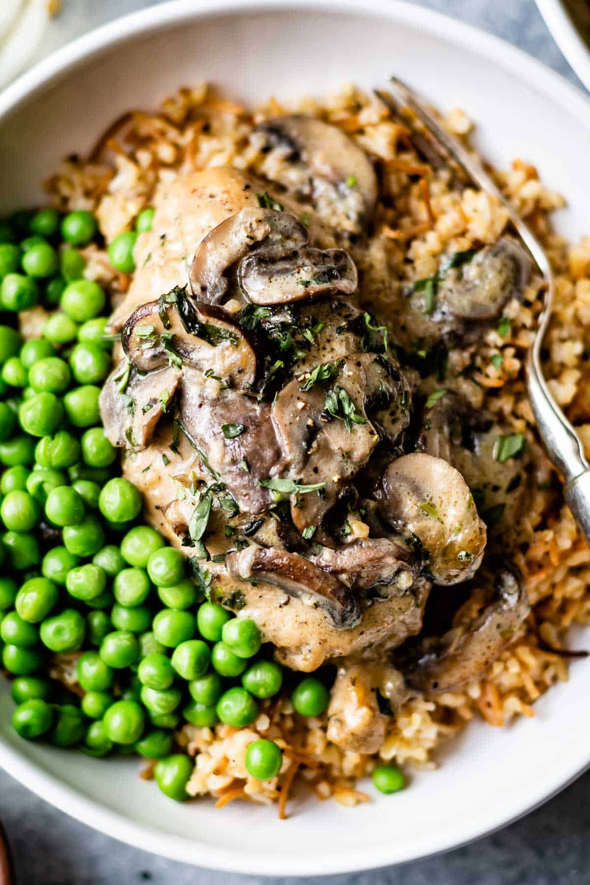 Chicken Fricassee in a bowl served with peas and rice
