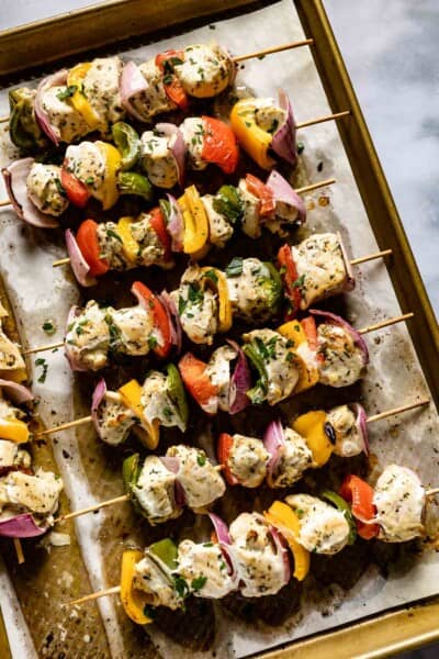 Oven chicken kabobs in a baking sheet from the top view.