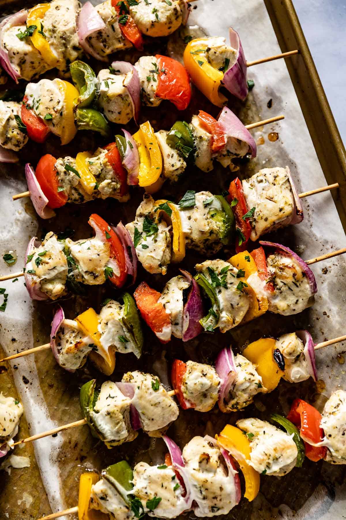 Baked chicken skewers in a sheet pan from the top view.