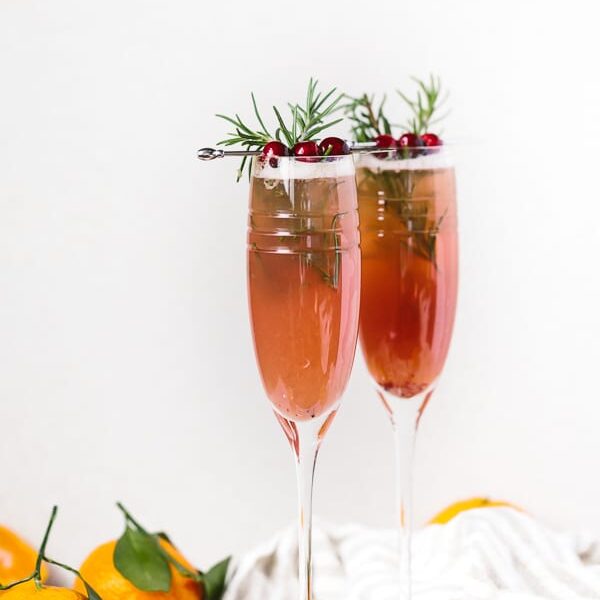 2 flutes of Clementine Cranberry Prosecco Cocktail: An easy to make cranberry and clementine flavored prosecco cocktail recipe for all your upcoming holiday parties.