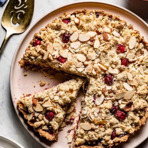 Cranberry almond flour tart with a slice cut from the top view.