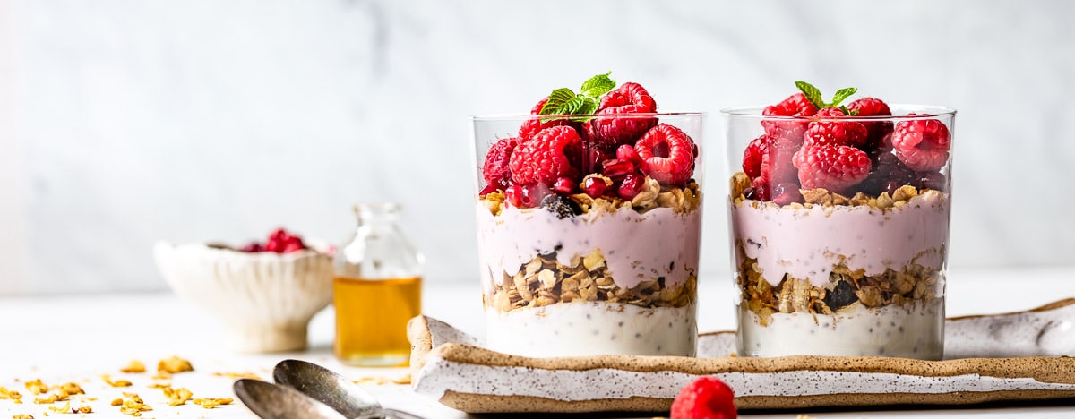 two bowls of yogurt parfait with raspberries