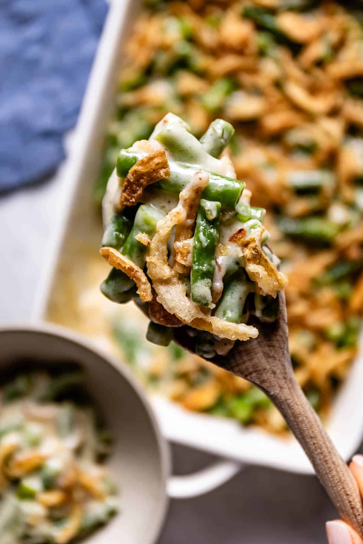 Green bean casserole without mushroom soup on a wooden spoon.