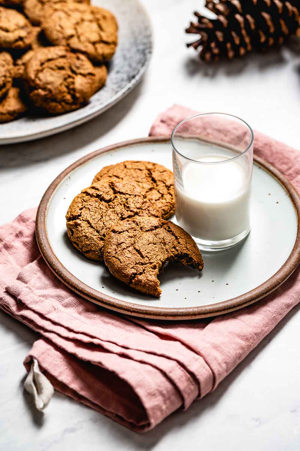 A few Almond flour gingerbread cookies served with a glass of milk on the side.