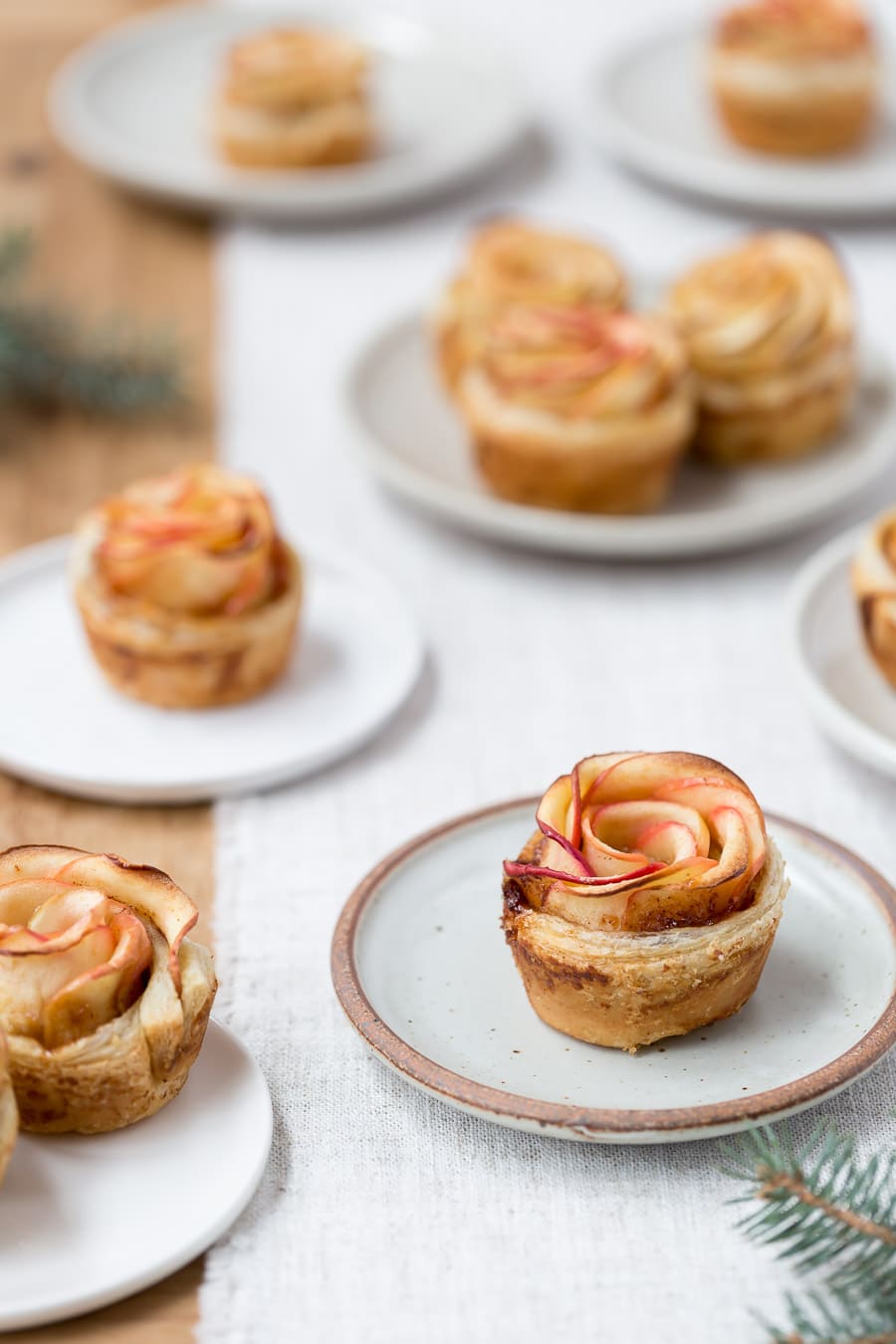 How to make apple roses pastry - Freshly baked apple roses are photographed on small plates.