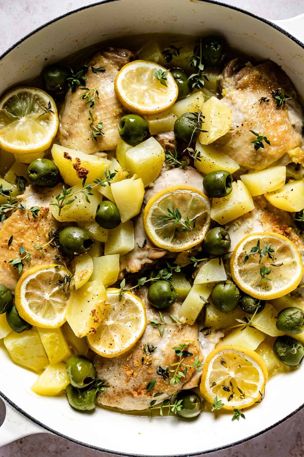 Baked Mediterranean chicken with lemon is in a skillet from the top view.