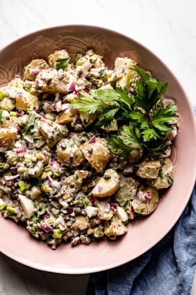 potato salad with capers, herbs and eggs in a bowl from the top view