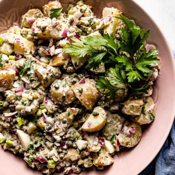 potato salad with capers, herbs and eggs in a bowl from the top view
