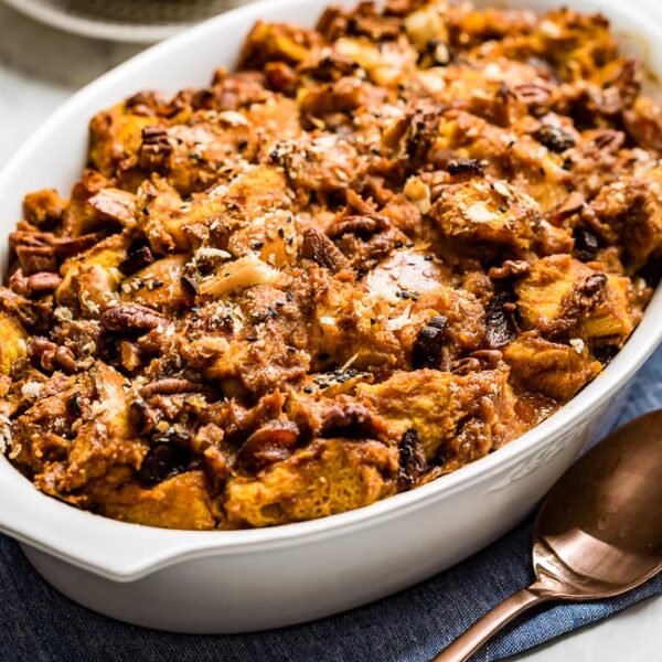 Pumpkin Bread Pudding in a casserole dish with a spoon on the side
