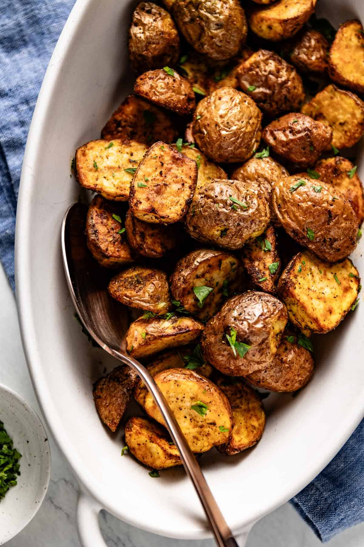Air fried red potatoes garnished with parsley in a bowl.