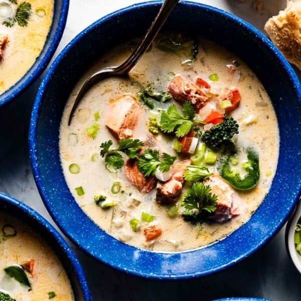 Salmon coconut soup in bowls with bread on the side.